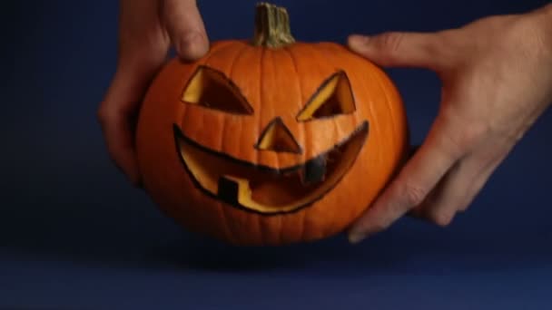A young man, holds out a halloween pumpkin or jack-o-lantern . The young master made a jack-o-lantern for the Halloween party. — Stock Video