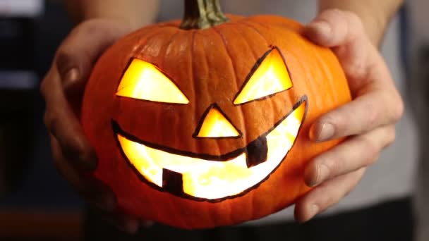 Mladý pán vyrobil lucernu na Halloweenskou párty. Mladý muž, drží v ruce halloween dýni nebo jack-o-lucernu. . — Stock video