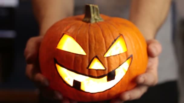 Mladý pán vyrobil lucernu na Halloweenskou párty. Mladý muž, drží v ruce halloween dýni nebo jack-o-lucernu. . — Stock video