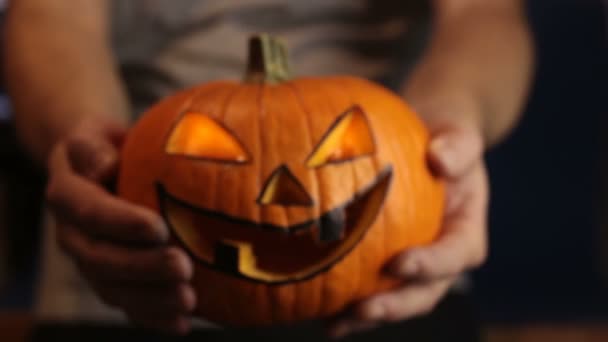 Młody mistrz zrobił jack-o-latarnię na imprezę halloweenową.Młody człowiek, trzyma halloween dyni lub jack-o-latarnia . — Wideo stockowe