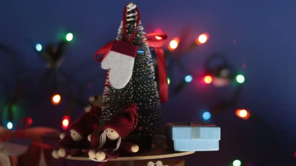 Carrossel de Natal com uma árvore de Natal e presentes brilhantes. Ano Novo árvore festiva com presentes no fundo de uma grinalda brilhante.Decoração para o ano novo. — Vídeo de Stock