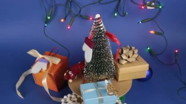 Noel ağacı ve parlak hediyeli bir Noel atlıkarınca. Parlak bir çelengin arka planında hediyelerle yılbaşı ağacı. Yeni yıl için dekorasyon..