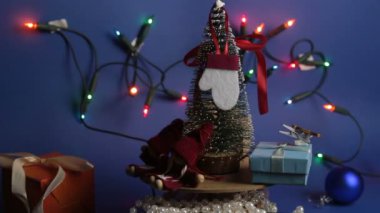 Parlak bir çelengin arka planında hediyeler olan yeni yıl ağacı. Yeni yıl için dekorasyon. Noel ağacı ve parlak hediyeli Noel atlıkarınca..