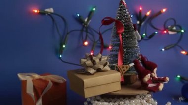 Parlak bir çelengin arka planında hediyeler olan yeni yıl ağacı. Yeni yıl için dekorasyon. Noel ağacı ve parlak hediyeli Noel atlıkarınca..