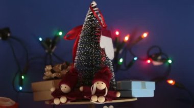 Parlak bir çelengin arka planında hediyeler olan yeni yıl ağacı. Yeni yıl için dekorasyon. Noel ağacı ve parlak hediyeli Noel atlıkarınca..