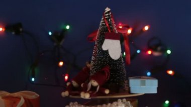 Parlak bir çelengin arka planında hediyeler olan yeni yıl ağacı. Yeni yıl için dekorasyon. Noel ağacı ve parlak hediyeli Noel atlıkarınca..