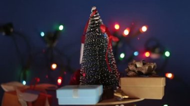 Parlak bir çelengin arka planında hediyeler olan yeni yıl ağacı. Yeni yıl için dekorasyon. Noel ağacı ve parlak hediyeli Noel atlıkarınca..