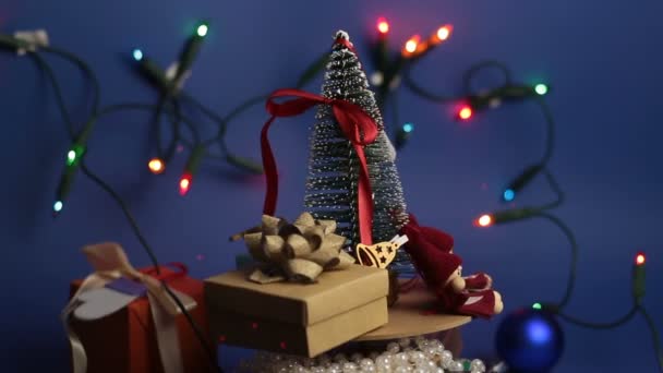 Χριστουγεννιάτικο καρουζέλ με χριστουγεννιάτικο δέντρο και φωτεινά δώρα. Πρωτοχρονιάτικο εορταστικό δέντρο με δώρα στο φόντο μιας λαμπρής γιρλάντας. Διακόσμηση για το νέο έτος. — Αρχείο Βίντεο
