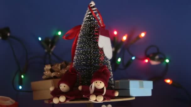 Capodanno albero di festa con regali sullo sfondo di una ghirlanda luminosa.Decorazione per il nuovo anno.Giostra di Natale con un albero di Natale e regali luminosi. — Video Stock