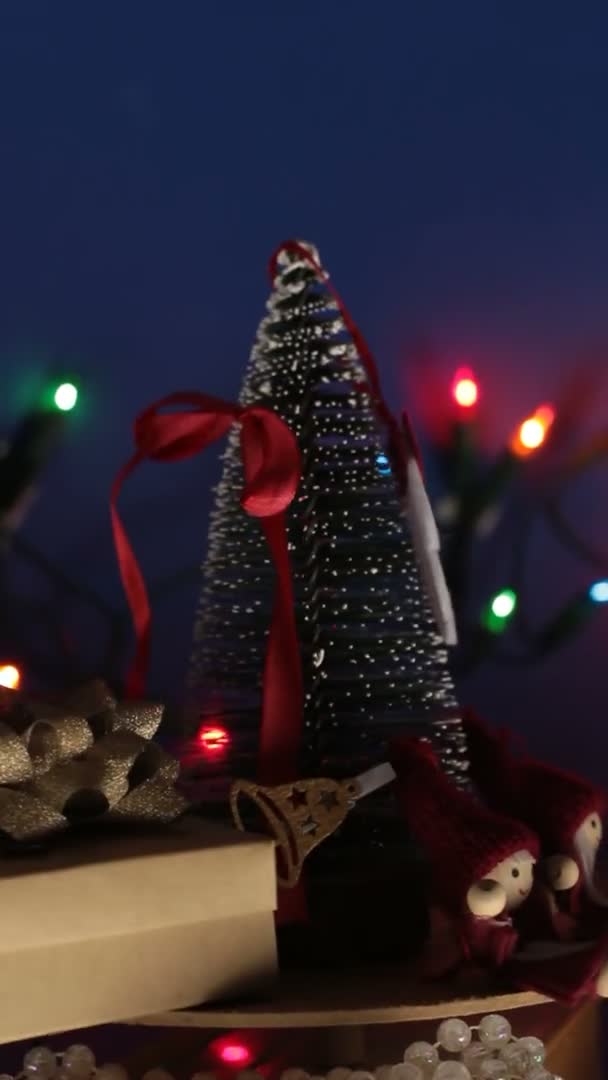 Vídeo vertical Árvore festiva de Ano Novo com presentes no fundo de uma grinalda brilhante.Decoração para o novo ano.Carrossel de Natal com uma árvore de Natal e presentes brilhantes. — Vídeo de Stock