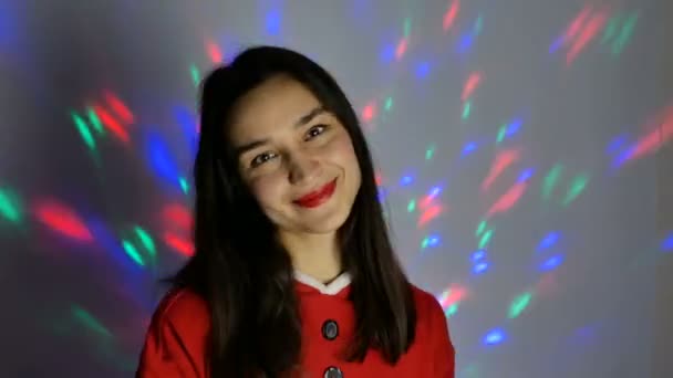 Молодая Привлекательная Женщина Новогоднем Костюме Широко Улыбается Фоне Разноцветной Гирлянды — стоковое видео