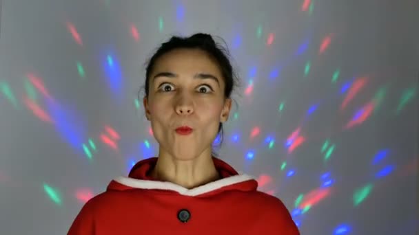 Retrato de cerca de una joven mujer feliz, en un ambiente festivo, sueña con regalos de Año Nuevo, sonríe y levanta un pequeño árbol de Navidad. preparándose para la Navidad. — Vídeo de stock