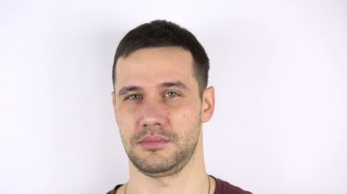 Yakışıklı bir gencin yüzüne ringa balığıyla vurulmasının yavaş çekimi. Genç yakışıklı adamın yüzüne taze balık çarpıyor..