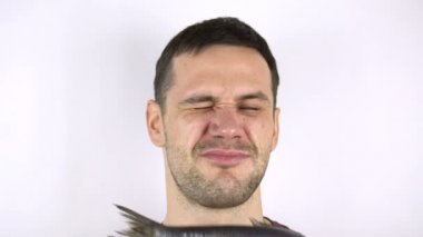 Genç yakışıklı adamın yüzüne taze balık çarpıyor..