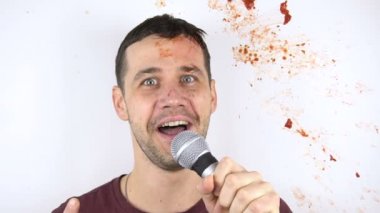 Yavaş çekimde, bir domates konuşması sırasında genç bir stand-up komedyeninin yüzüne çarpar..