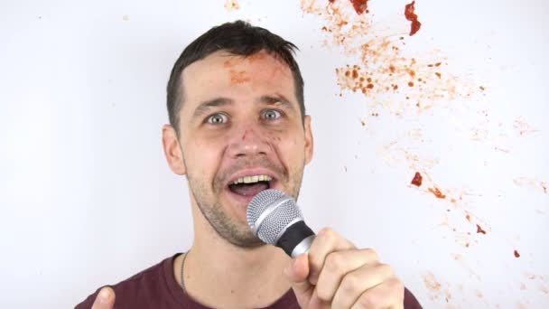 Em câmera lenta, um tomate bate contra o rosto de um jovem comediante stand-up durante seu discurso. — Vídeo de Stock