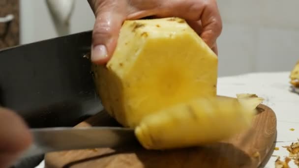Närbild kvinnlig kock skär saftig mogen ananas i köket.Kvinna kock skalar mogen saftig ananas från skalet. — Stockvideo