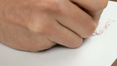 Genç bir adamın eli, kağıda kırmızı kalemle 