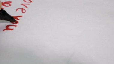 Sevgililer Günü için tebrik kartı hazırlıyorum. Genç bir adam kız arkadaşı için sevgililer günü kartı çekiyor..