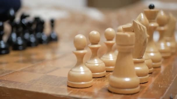 Üzerinde parçalar olan satranç tahtası. Satranç taşlarının yakın çekimi eski bir satranç tahtasının üzerinde duruyor.. — Stok video