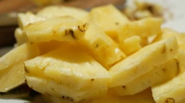 Genç bir adam kendine tatlı, sulu bir ananas ısmarlar. Genç bir adamın elleri, olgun, sulu bir ananas dilimini tabaktan alır..