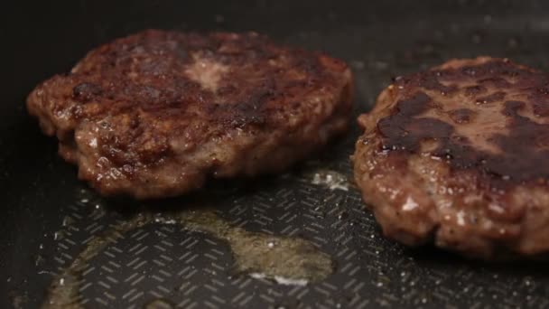 Koki menempatkan roti daging sapi ke dalam penggorengan. daging sapi Juicy digoreng dalam panci. — Stok Video