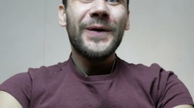 Genç ve çekici bir erkek kutuyu açar ve hediyeyle mutlu olur. Genç ve mutlu bir adam hediyeyle şaşırdı, mutlu bir şekilde kutuyu açtı..