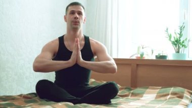 Genç ve çekici bir adam oturma odasında yatağında Assanas çalıyor. Genç adam evde nefes egzersizleri yapıyor ve meditasyon yapıyor. Genç mutlu adam Lotus 'ta otururken meditasyon yapıyor.