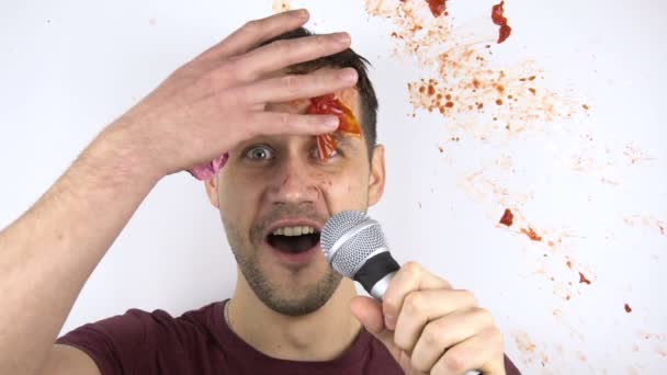 Ein junger attraktiver Stand-up-Comedian wird wegen schlechter Leistung mit Tomaten erschossen. Ein junger attraktiver Kerl wird in Zeitlupe von einer faulen Tomate ins Gesicht geschlagen. — Stockvideo