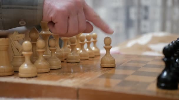 Een oudere man en een jonge vrouw arrangeren schaakstukken op een schaakbord, maken zich klaar om te spelen.Close-up van de hand van een man en een jonge vrouw die schaak spelen. — Stockvideo