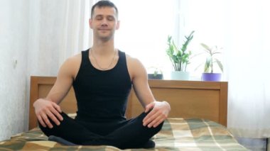 Genç ve çekici bir adam oturma odasında yatağında Assanas çalıyor. Genç adam evde nefes egzersizleri yapıyor ve meditasyon yapıyor. Genç mutlu adam Lotus 'ta otururken meditasyon yapıyor.