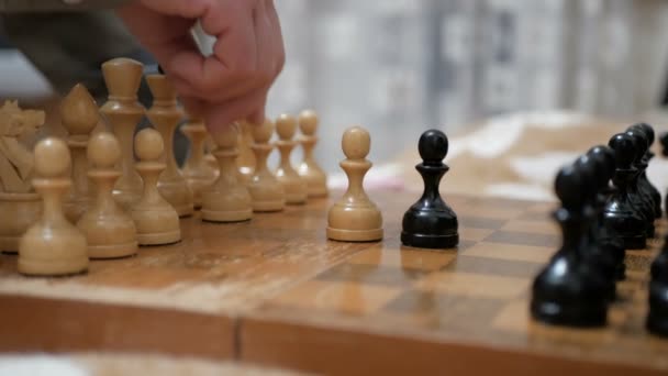 Ένας ηλικιωμένος άνδρας και μια νεαρή γυναίκα οργανώνουν πιόνια στο σκάκι σε μια σκακιέρα, ετοιμάζονται να παίξουν.Κοντινό πλάνο του χεριού ενός άνδρα και μιας νεαρής γυναίκας που παίζουν σκάκι.. — Αρχείο Βίντεο