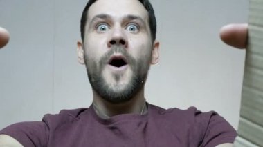 Genç ve çekici bir erkek kutuyu açar ve hediyeyle mutlu olur. Genç ve mutlu bir adam hediyeyle şaşırdı, mutlu bir şekilde kutuyu açtı..