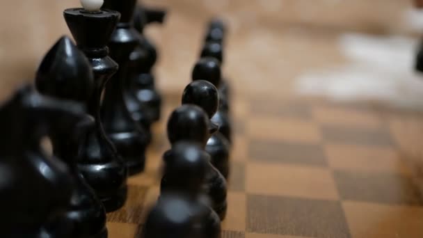チェス盤の上に駒が置かれているチェス盤の近くには古いチェス盤が立っている。. — ストック動画