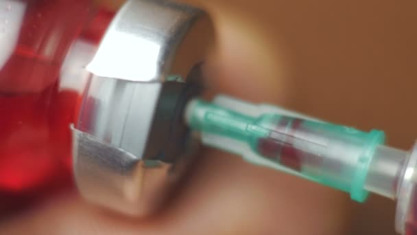 医生把疫苗从药瓶中抽到注射器里 保健概念 用红色疫苗进行无菌注射器的特写拍摄 — 图库视频影像