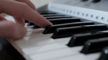 Konser sırasında sentezleyici çalan profesyonel bir müzisyenin ellerinin yakın çekimi..