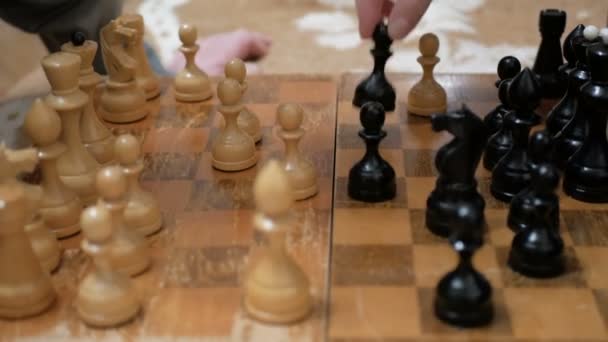 Close-up van de hand van een man en een jonge vrouw die schaakt.Een oudere man en een jonge vrouw arrangeren schaakstukken op een schaakbord, maken zich klaar om te schaken. — Stockvideo