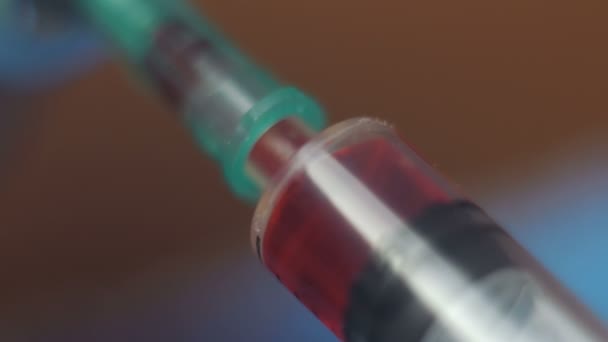 의사는 병에서 백신을 주사기에 넣습니다. 살균 주사기의 근접 사진에 붉은 백신 이 있습니다. 건강 관리 개념. — 비디오