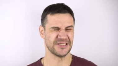 Genç bir adamın yanaklarına ağır ağır vurulur. Genç ve çekici bir erkek, kız arkadaşından tokat yer. Elin avuç içiyle yanağa ağır bir darbe almış..