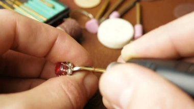 Profesyonel bir oymacı bir mücevher parçası yaratır. Mücevher işleme, profesyonel bir kuyumcunun mücevher cilalaması. Bir kuyumcu altın bir yüzüğün değerli taşını kesiyor. Profesyonel bir kuyumcu.