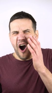 Dikey video. Genç ve çekici bir adam kız arkadaşından tokat yer. Yavaşça yanağına avuç içi ile vur. Genç bir adamın yanağına ağır çekimde bir el vurulur..