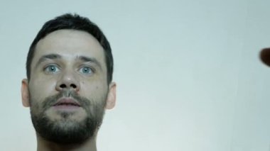 Genç ve çekici bir erkek kutuyu açar ve hediyeyle mutlu olur. Genç ve mutlu bir adam hediyeyle şaşırdı, mutlu bir şekilde kutuyu açtı..