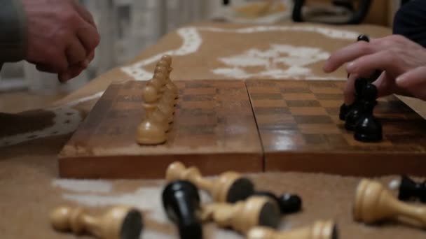 Ένας ηλικιωμένος άνδρας και μια νεαρή γυναίκα οργανώνουν πιόνια στο σκάκι σε μια σκακιέρα, ετοιμάζονται να παίξουν.Κοντινό πλάνο του χεριού ενός άνδρα και μιας νεαρής γυναίκας που παίζουν σκάκι.. — Αρχείο Βίντεο