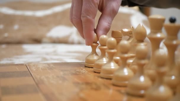 Een oudere man en een jonge vrouw arrangeren schaakstukken op een schaakbord, maken zich klaar om te spelen.Close-up van de hand van een man en een jonge vrouw die schaak spelen. — Stockvideo