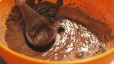 Çikolata hamurunu kek yapmak için mikserle karıştıran şefin yakın çekimi. Şef çikolatalı kremayı mikserle karıştırıyor..