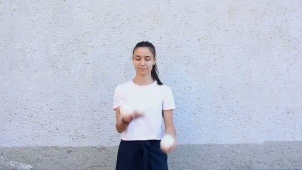 Atraktivní žonglérka trénuje své žonglérské schopnosti. Profesionální žonglér s bílými koulemi. Profesionální cirkus performer žongluje bílé koule na ulici. — Stock video