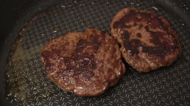 Le chef met des galettes de bœuf dans une poêle. escalope de bœuf juteuse est frit dans une poêle. — Video