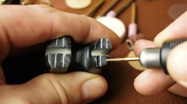 Profesyonel bir kuyumcu taş bir heykele mücevher yapmak için kazımış. Profesyonel bir oymacı özel bir kesiciyle oyuklar yaparak bir mücevher oluşturur..