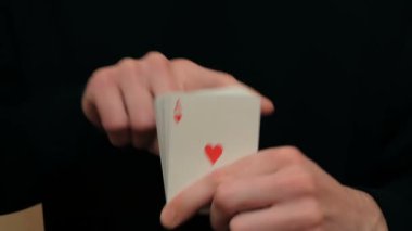Genç bir erkek sihirbazın eli ile bir deste iskambil kağıdından hayran yapıyor. Genç bir sihirbaz sihirli bir numara gösteren bir deste kağıttan yelpaze yapar..
