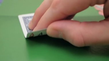 Profesyonel bir poker oyuncusunun elinde iki as. Poker oyuncusu bahsi artırmadan önce kartlarını kontrol eder. Profesyonel poker oyuncusunun iki ası vardır. Kumar anlayışı. Profesyonel.